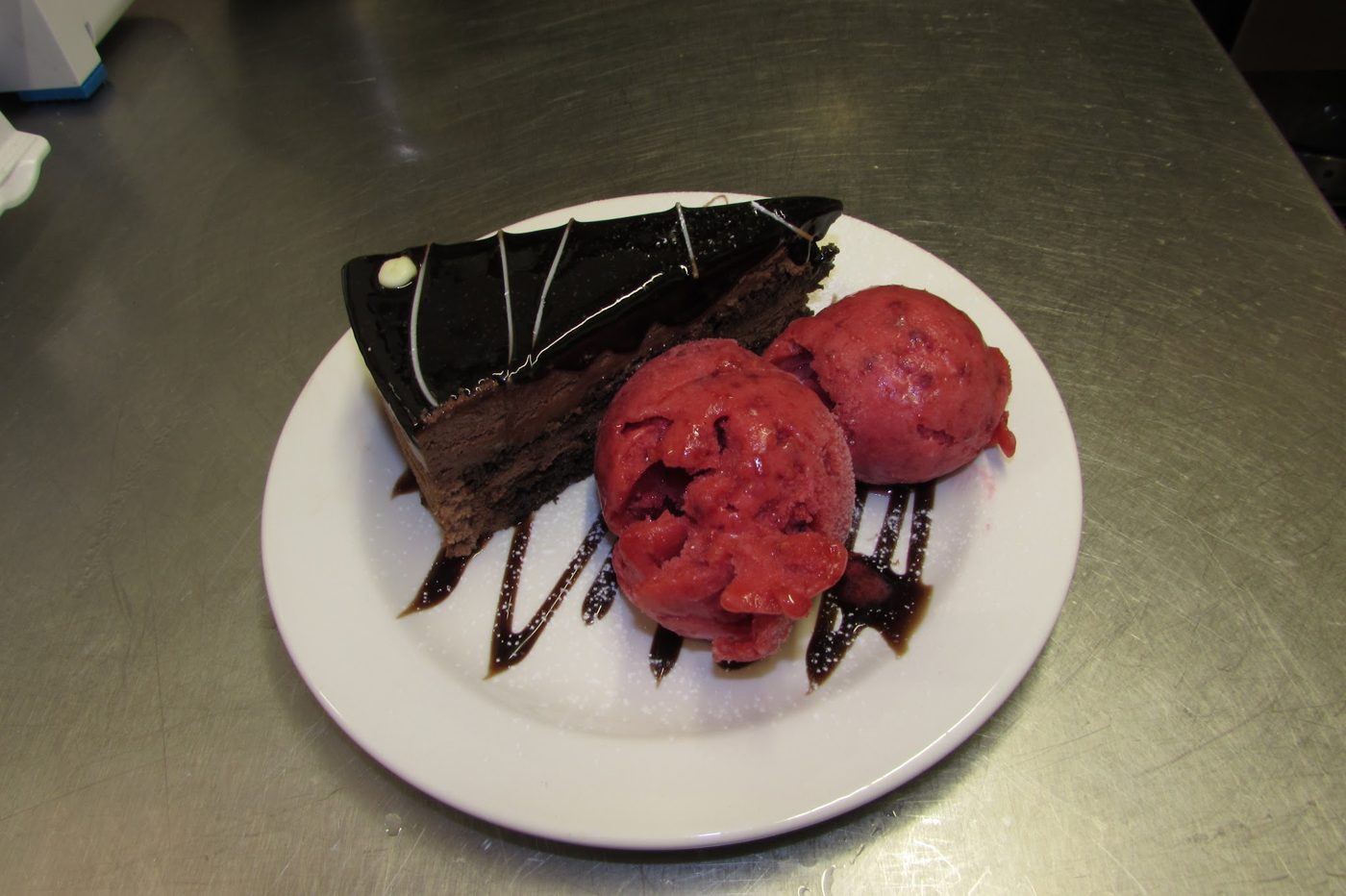 A slice of chocolate cake with sorbet