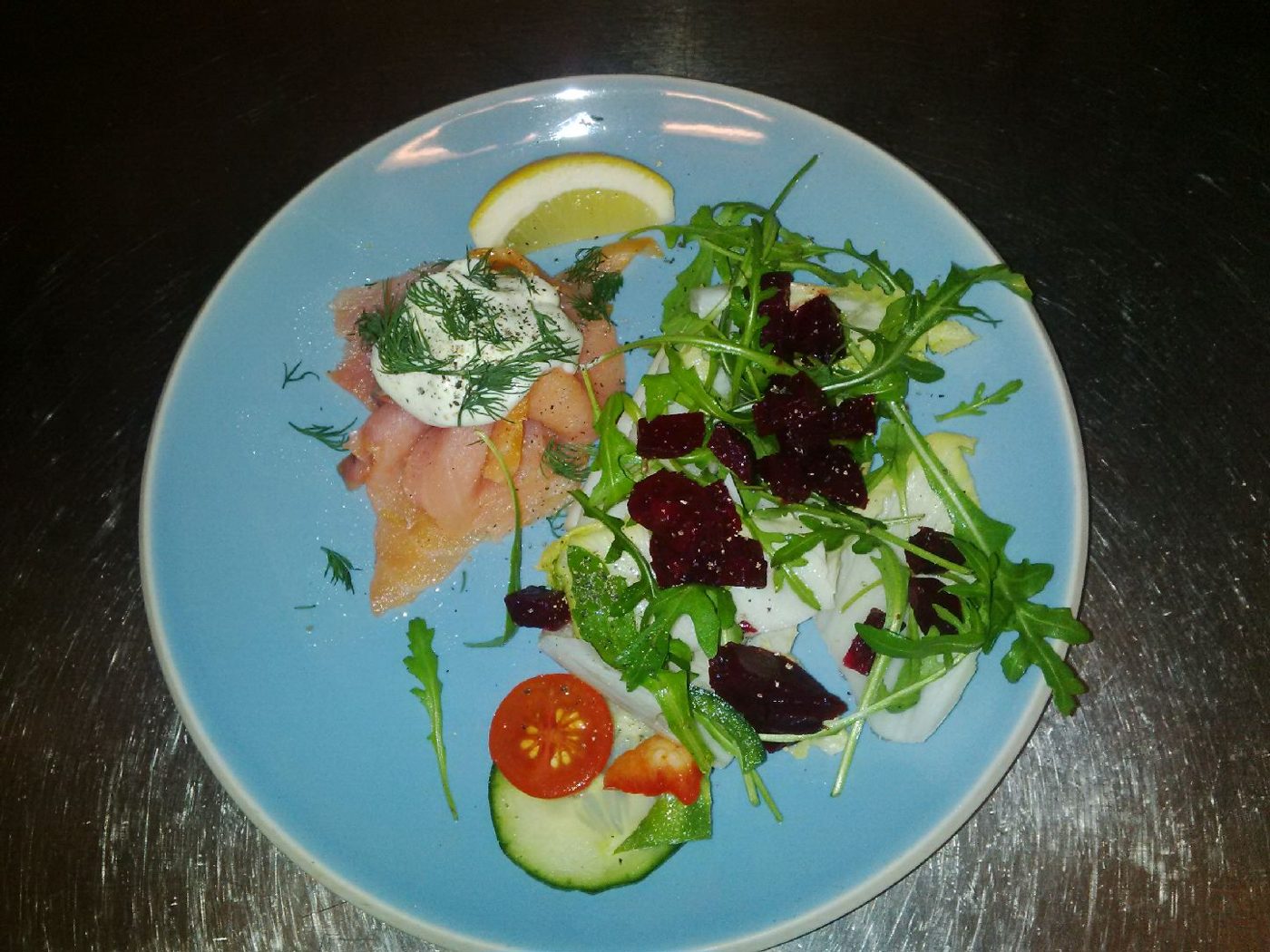 Smoked salmon with salad on a blue plate